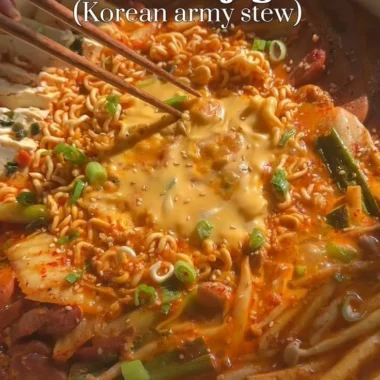 Delicious Army Stew (Budae Jjigae) topped with cheese and Spam, served in a hot pot.