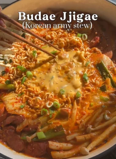 Delicious Army Stew (Budae Jjigae) topped with cheese and Spam, served in a hot pot.
