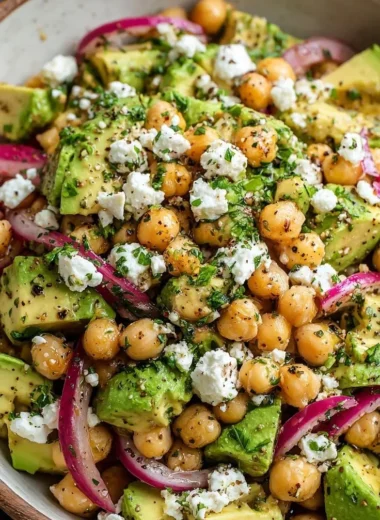 Chickpea Feta Avocado Salad garnished and served in a bowl with fresh ingredients.