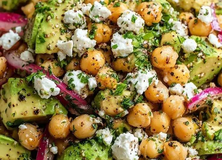 Chickpea Feta Avocado Salad garnished and served in a bowl with fresh ingredients.