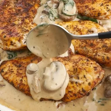 Creamy mushroom chicken served on a plate with fresh herbs and sides