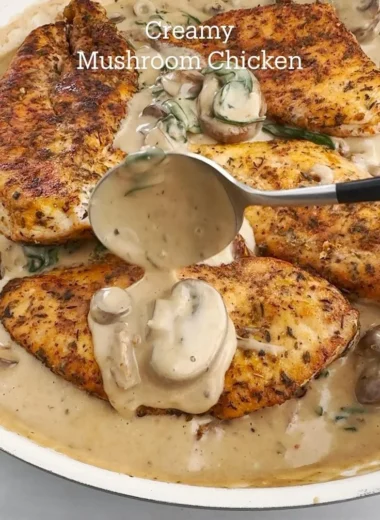 Creamy mushroom chicken served on a plate with fresh herbs and sides