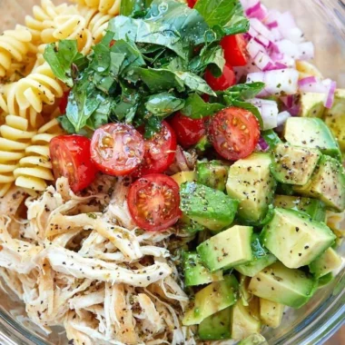 Healthy chicken pasta salad with fresh vegetables and dressing.