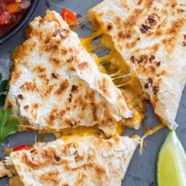 Delicious chicken quesadillas served on a plate with salsa and garnish.