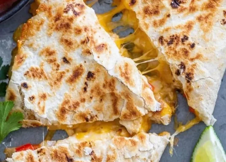 Delicious chicken quesadillas served on a plate with salsa and garnish.