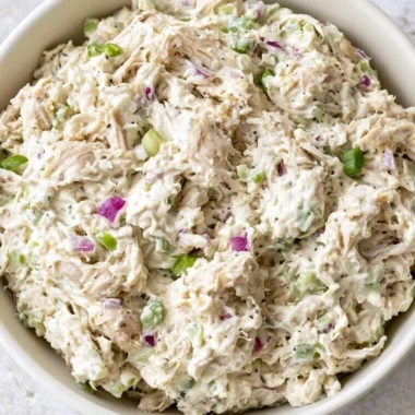 A bowl of fresh and colorful Chicken Salad with vegetables and dressing