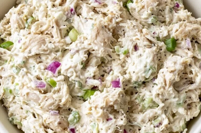 A bowl of fresh and colorful Chicken Salad with vegetables and dressing