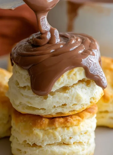Delicious creamy chocolate biscuit gravy served in a bowl with biscuits.