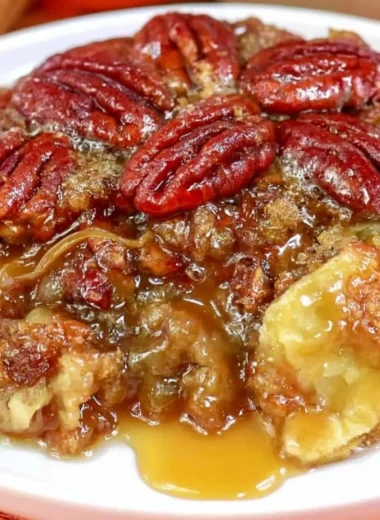 Dixie's Pecan Pie Cobbler served in a bowl with a scoop of vanilla ice cream on top
