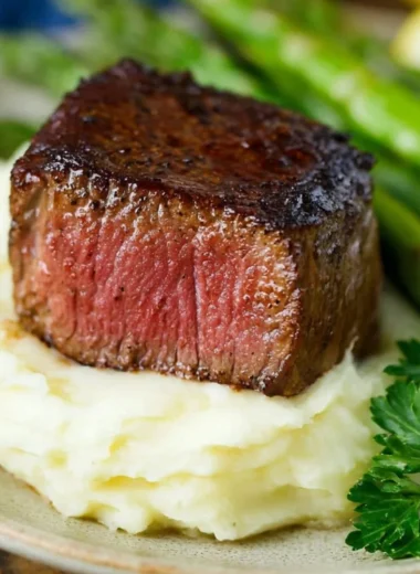 Delicious Filet Mignon topped with Garlic Herb Butter on a plate
