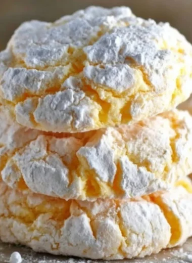 Lemon Cool Whip Cookies on a plate, garnished with lemon zest.