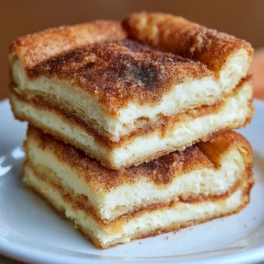 Delicious Mexican Churro Cheesecake Bars topped with cinnamon sugar and whipped cream.