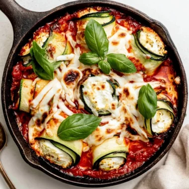Ricotta stuffed zucchini rolls on a plate with fresh herbs