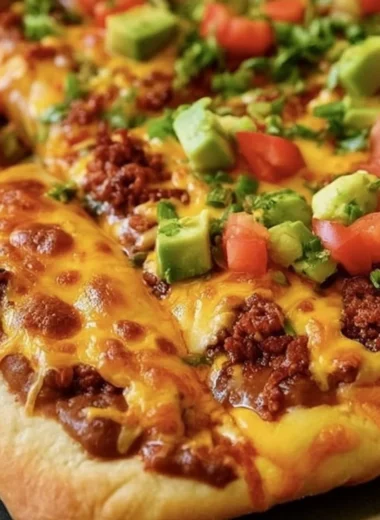Delicious Taco Pizza topped with seasoned beef, cheddar cheese, and fresh toppings.