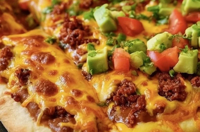 Delicious Taco Pizza topped with seasoned beef, cheddar cheese, and fresh toppings.