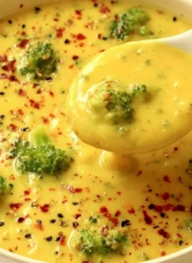 Bowl of vegan broccoli potato soup topped with fresh herbs and a drizzle of olive oil.