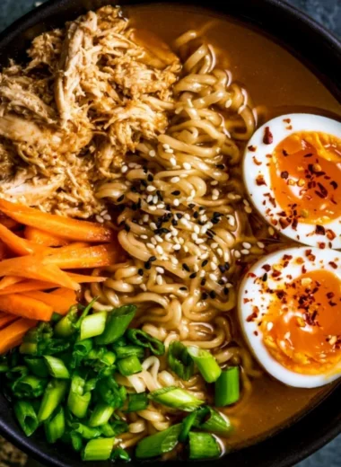 A bowl of 20 minute chicken ramen topped with green onions and herbs.