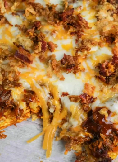 Delicious BBQ Bacon Cheeseburger Frito Pie topped with cheese and crispy bacon.