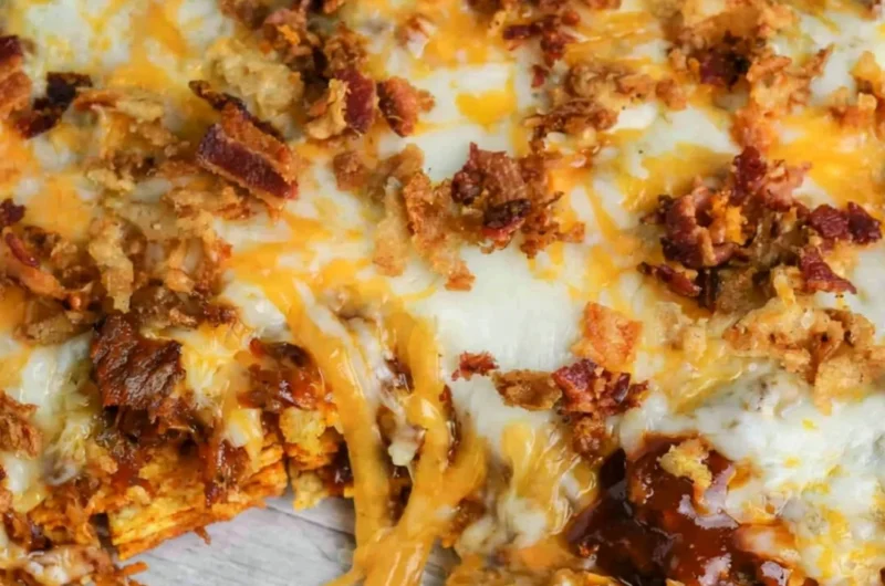 BBQ Bacon Cheeseburger Frito Pie topped with melted cheese and crispy bacon
