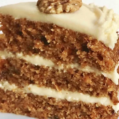Delicious slice of classic carrot cake topped with cream cheese frosting