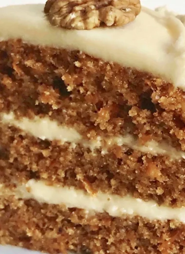 Delicious slice of classic carrot cake topped with cream cheese frosting