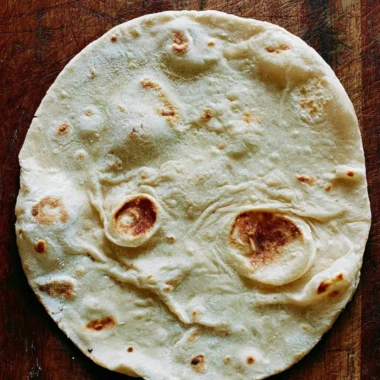Homemade cozy sourdough tortillas on a wooden table.