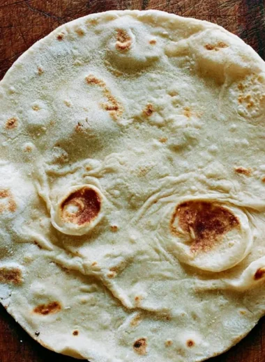 Homemade cozy sourdough tortillas on a wooden table.