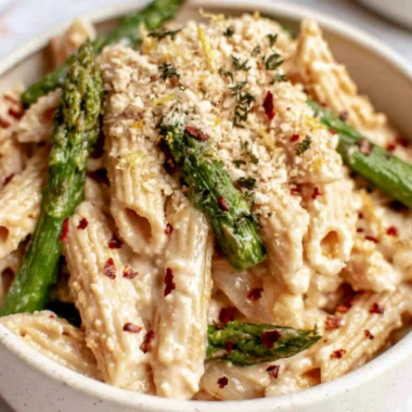 Bowl of creamy dairy-free lemon white bean pasta topped with fresh herbs