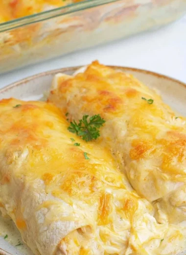 Creamy white chicken enchiladas topped with cheese and cilantro