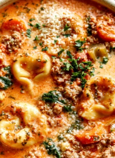 Delicious bowl of Crockpot Tortellini Soup garnished with herbs and cheese