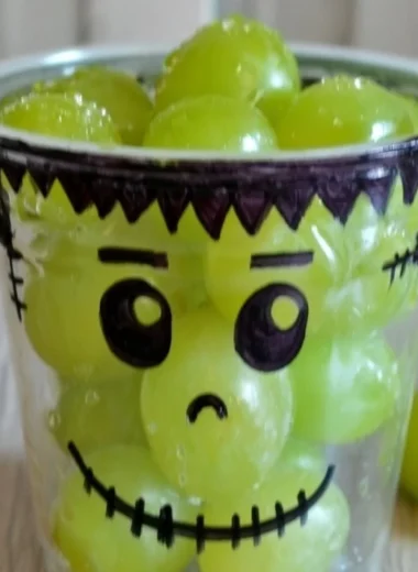 A variety of healthy Halloween snacks including fruits and veggies shaped like spooky characters