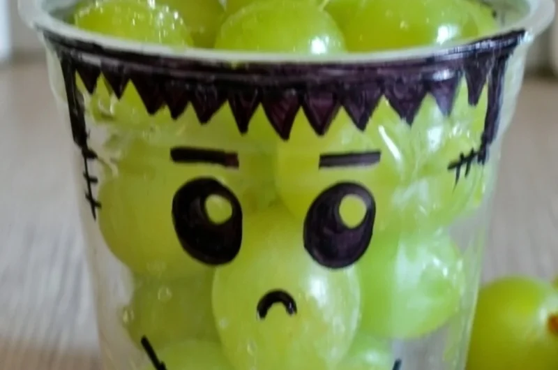 A variety of healthy Halloween snacks including fruits and veggies shaped like spooky characters