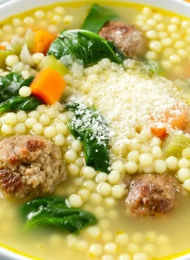 Bowl of Italian Wedding Soup with meatballs and fresh greens