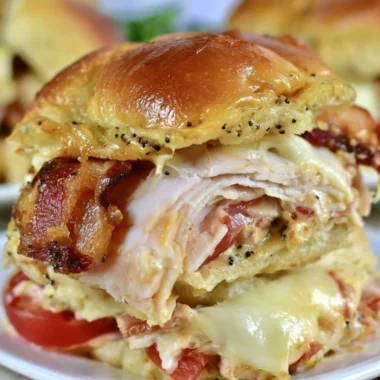 Kentucky Hot Brown Sliders topped with cheese and bacon, served on a platter.