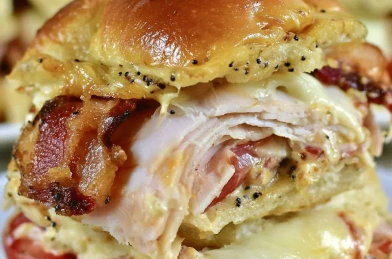 Kentucky Hot Brown Sliders topped with cheese and bacon, served on a platter.