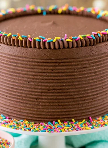 Moist yellow cake with rich chocolate frosting on a white plate