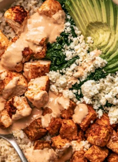 Roasted chicken served over sweet potato rice in a colorful bowl