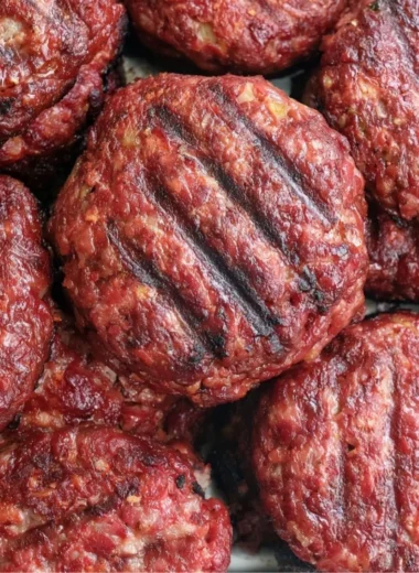 Delicious smoked burgers stacked with toppings on a plate