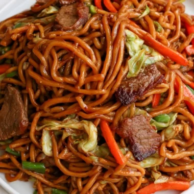 Delicious cozy beef lo mein topped with fresh vegetables and savory sauce