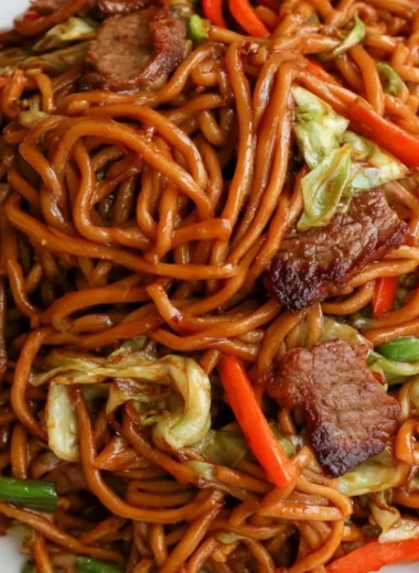 Delicious cozy beef lo mein topped with fresh vegetables and savory sauce