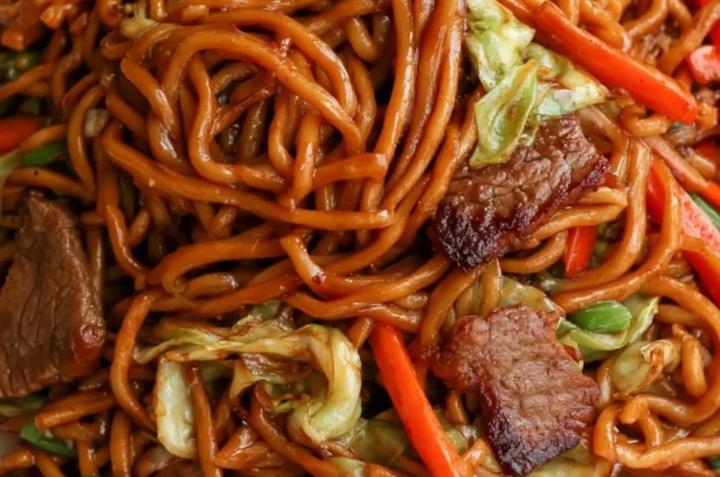 Delicious cozy beef lo mein topped with fresh vegetables and savory sauce