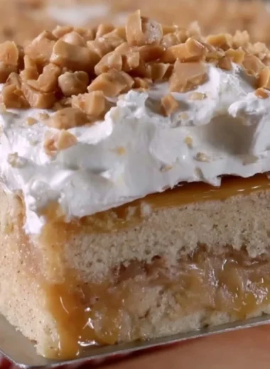Delicious caramel apple poke cake topped with drizzled caramel and apples