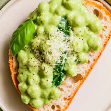 Creamy high protein pesto chickpeas served in a bowl with fresh basil