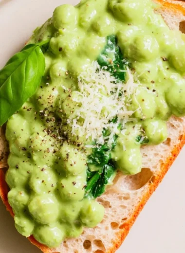 Creamy high protein pesto chickpeas served in a bowl with fresh basil