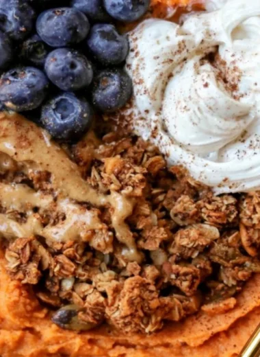 Fluffy sweet potato breakfast bowl topped with nuts and fruit