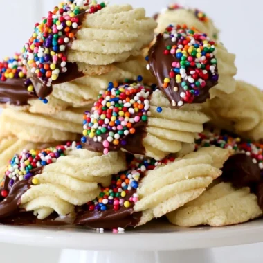 A plate of delicious Italian spritz cookies with colorful icing and sprinkles