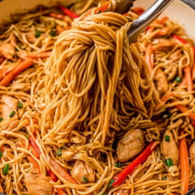 Bowl of quick and easy chicken lo mein topped with fresh vegetables