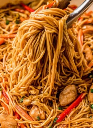 Bowl of quick and easy chicken lo mein topped with fresh vegetables