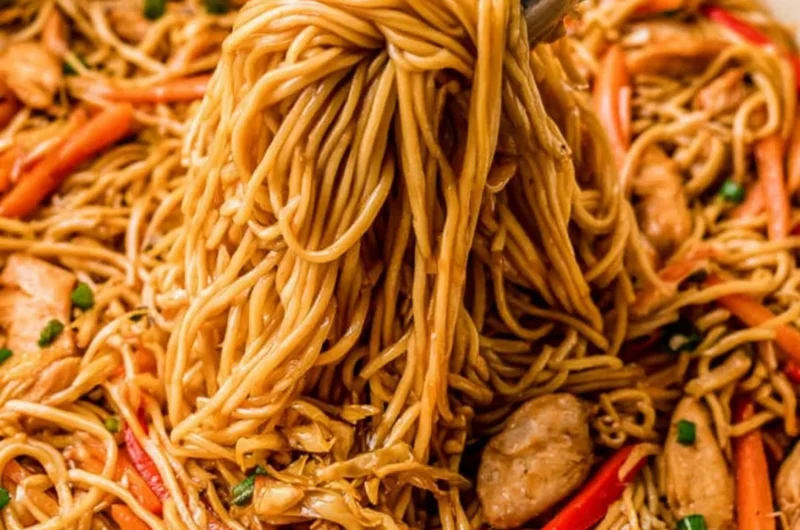 Bowl of quick and easy chicken lo mein topped with fresh vegetables